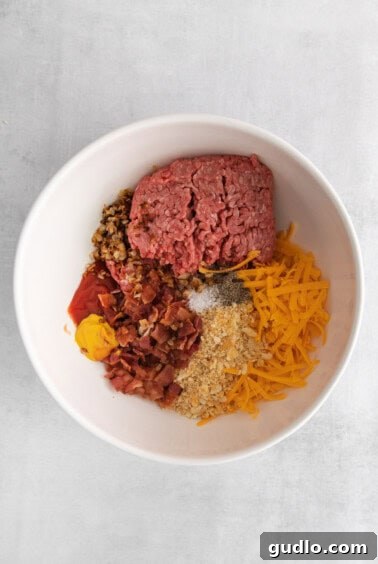 Burger Ball Bombs 5 Meatball ingredients mixed together in a large white bowl, ready for shaping.