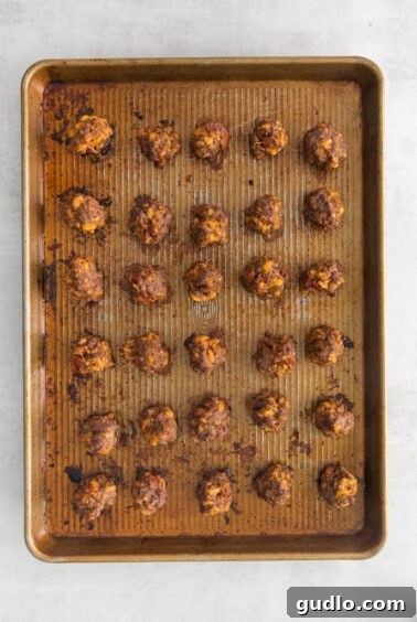 Burger Ball Bombs 7 A baking sheet filled with golden-brown baked cheeseburger meatballs.