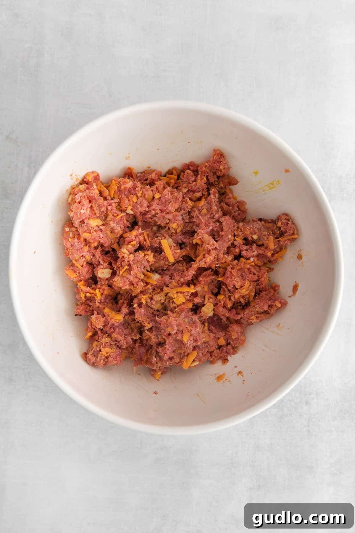 Meatball Mixture Ready for Shaping Raw cheeseburger meatball mixture in a large mixing bowl, ready for forming.