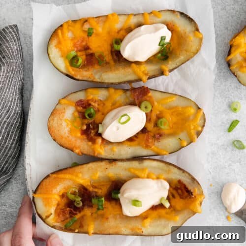 A platter of beautifully arranged cheesy potato skins, garnished and ready to serve.