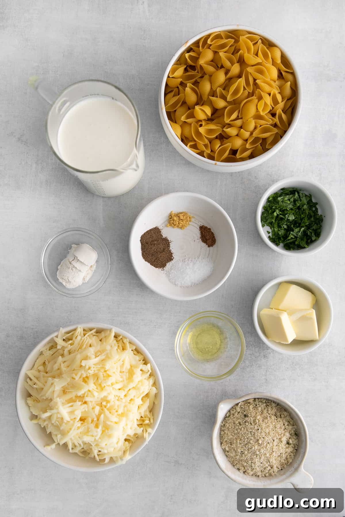 Decadent Truffle Mac 3 Neatly arranged ingredients for truffle mac and cheese, including pasta, cheese, and truffle oil, in small bowls.