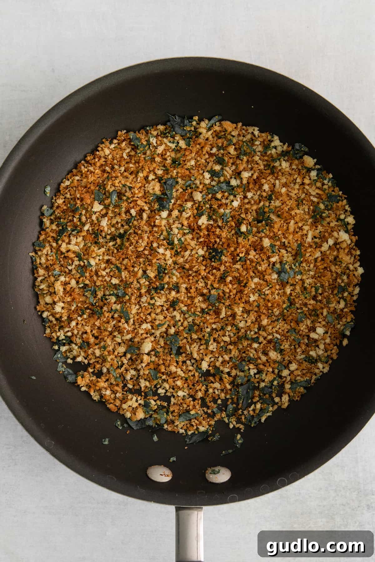 Decadent Truffle Mac 6 Golden brown panko breadcrumbs being toasted in a skillet with melted butter for the mac and cheese topping.