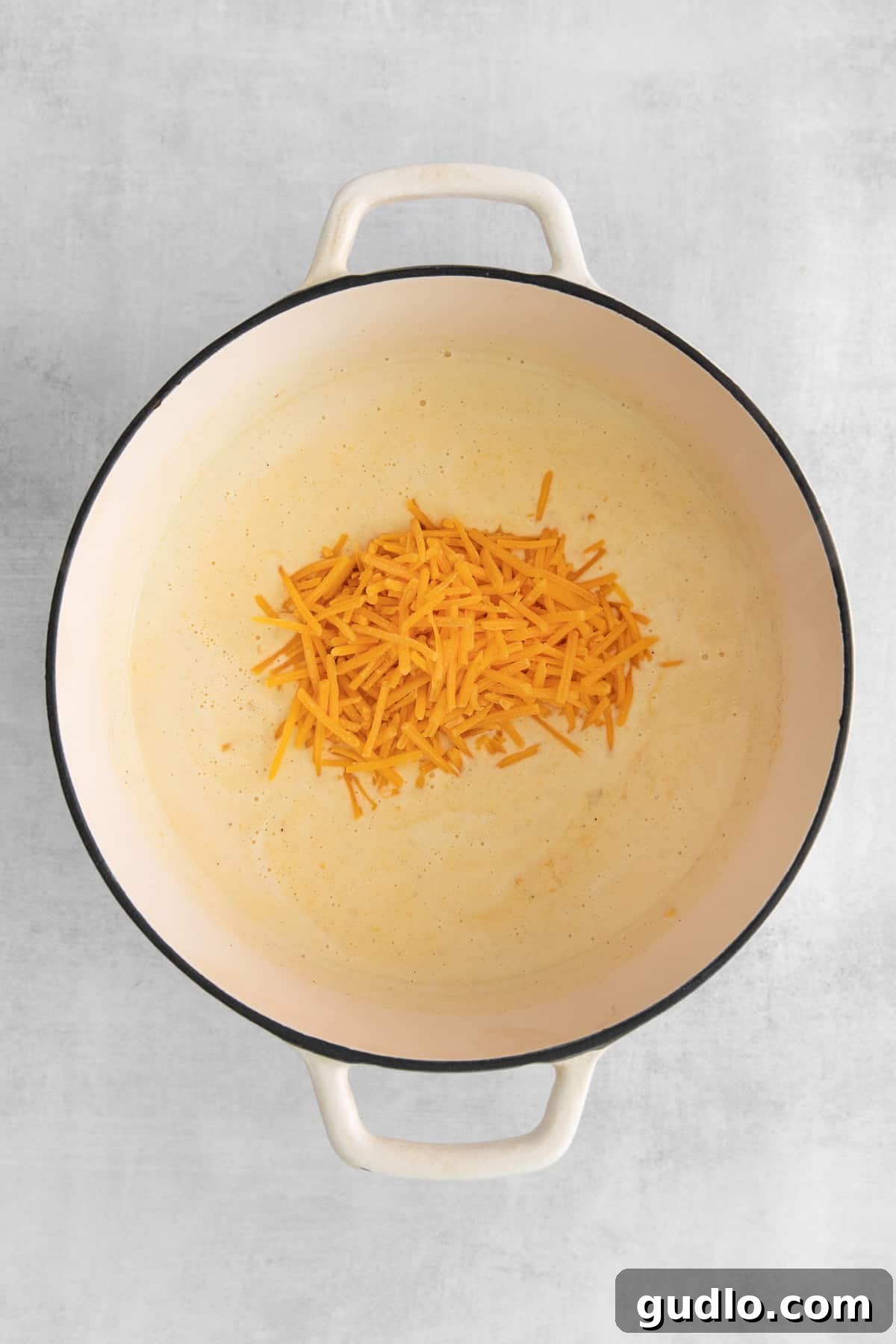Cheesy Roux in Dutch Oven A rich, bubbling cheesy roux mixture being stirred in a Dutch oven, signaling the start of a creamy soup.