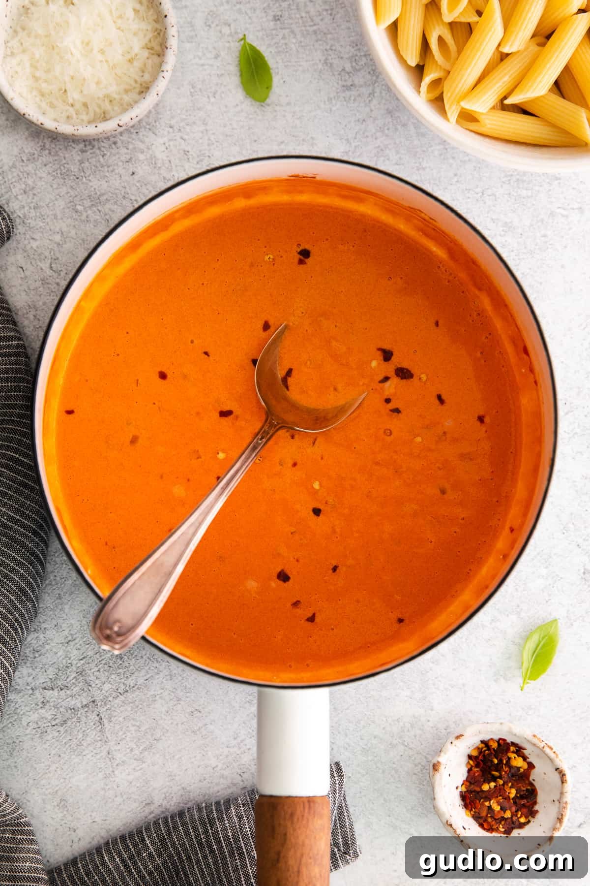 Spirited Tomato Cream 2 A pot of rich, creamy vodka sauce with a spoon dipped in it, ready to be served over pasta.