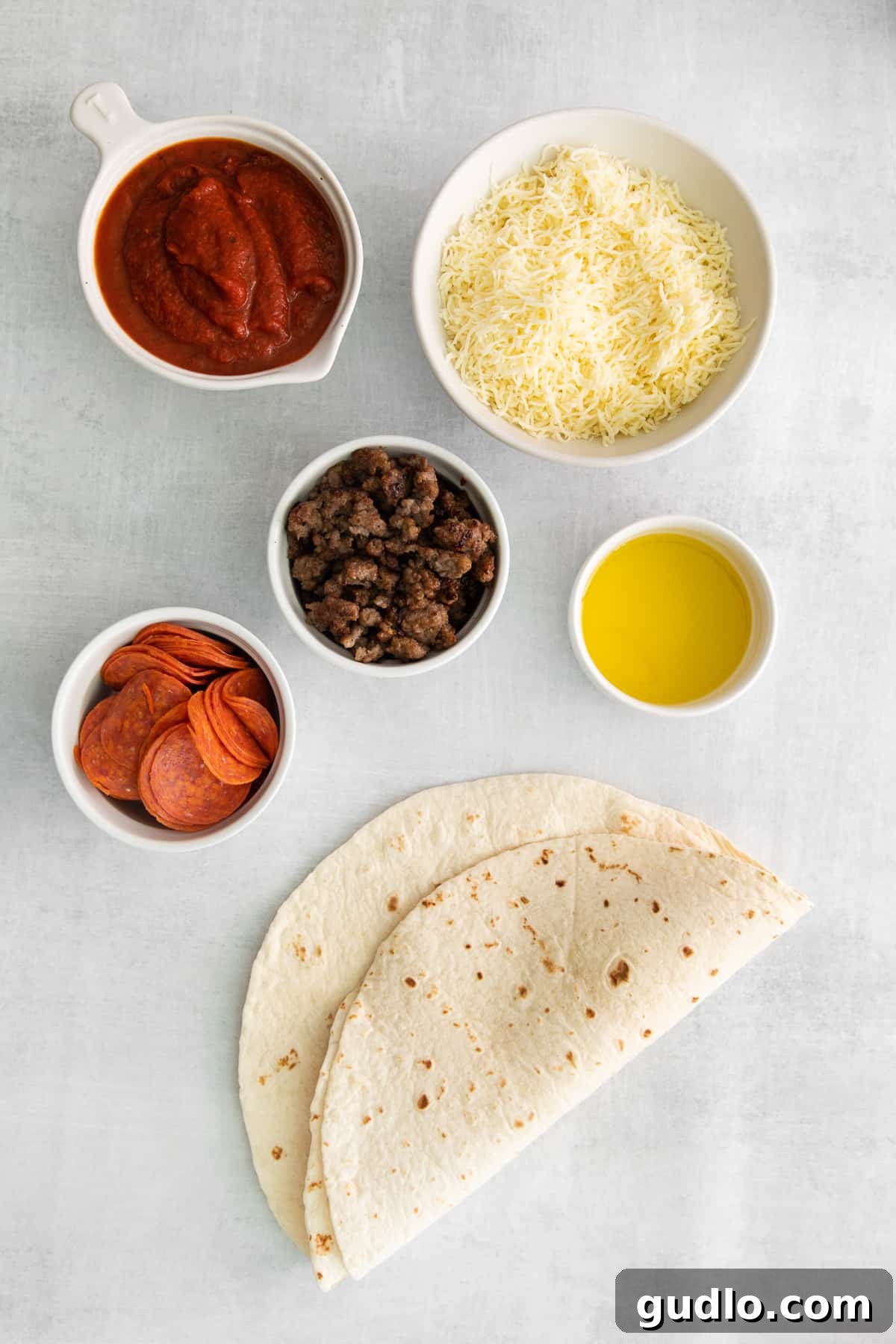 Pizza-Dilla Delight 3 Ingredients for pizza quesadillas laid out in small bowls: tortillas, sauce, cheese, pepperoni, and sausage.