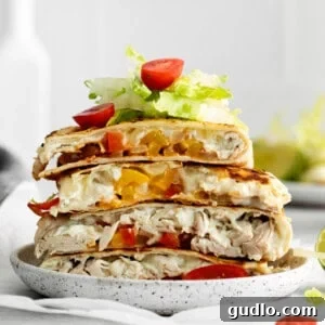Pizza-Dilla Delight 5 Chicken quesadillas served with dipping sauces on a wooden board.