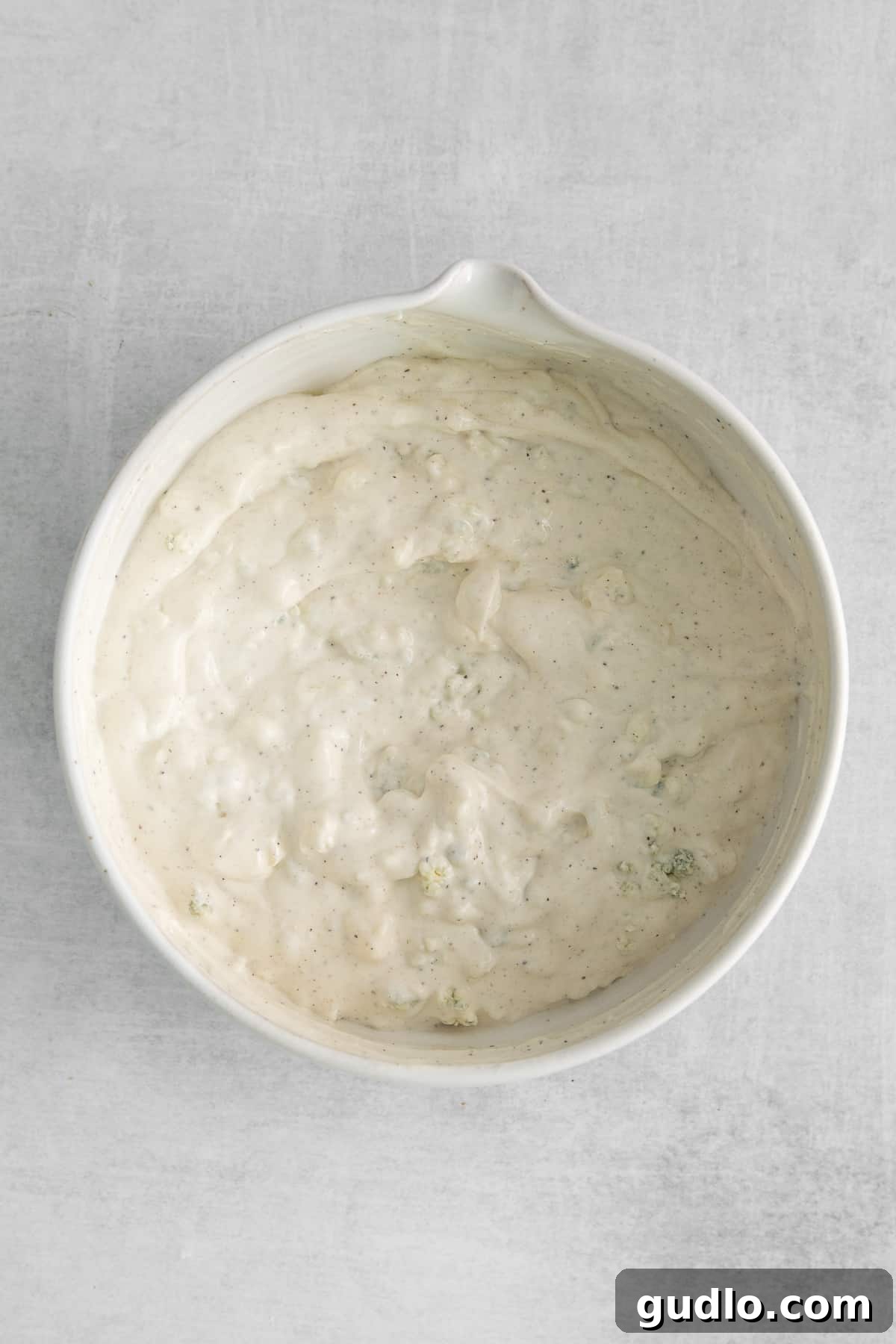 Creamy Gorgonzola Chicken Pasta Salad 5 A pristine white bowl showcasing a generous portion of creamy homemade gorgonzola dressing, perfectly blended and ready to be incorporated into the pasta salad.