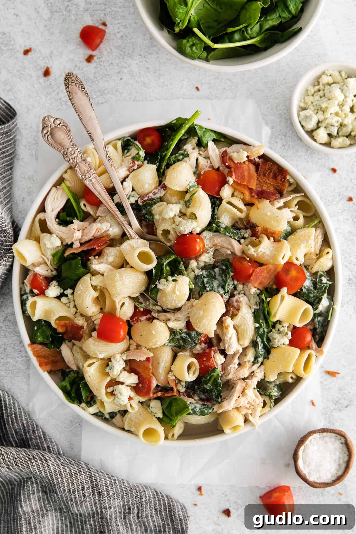 Creamy Gorgonzola Chicken Pasta Salad 8 A large, beautifully presented serving bowl brimming with Gorgonzola Chicken Pasta Salad, accompanied by elegant serving spoons, ready for effortless sharing among guests.