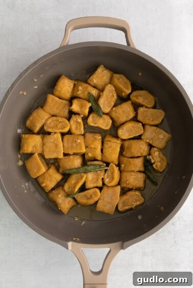Golden Pumpkin Pillows 7 Cooked pumpkin gnocchi tossed in a skillet with the sage butter sauce.