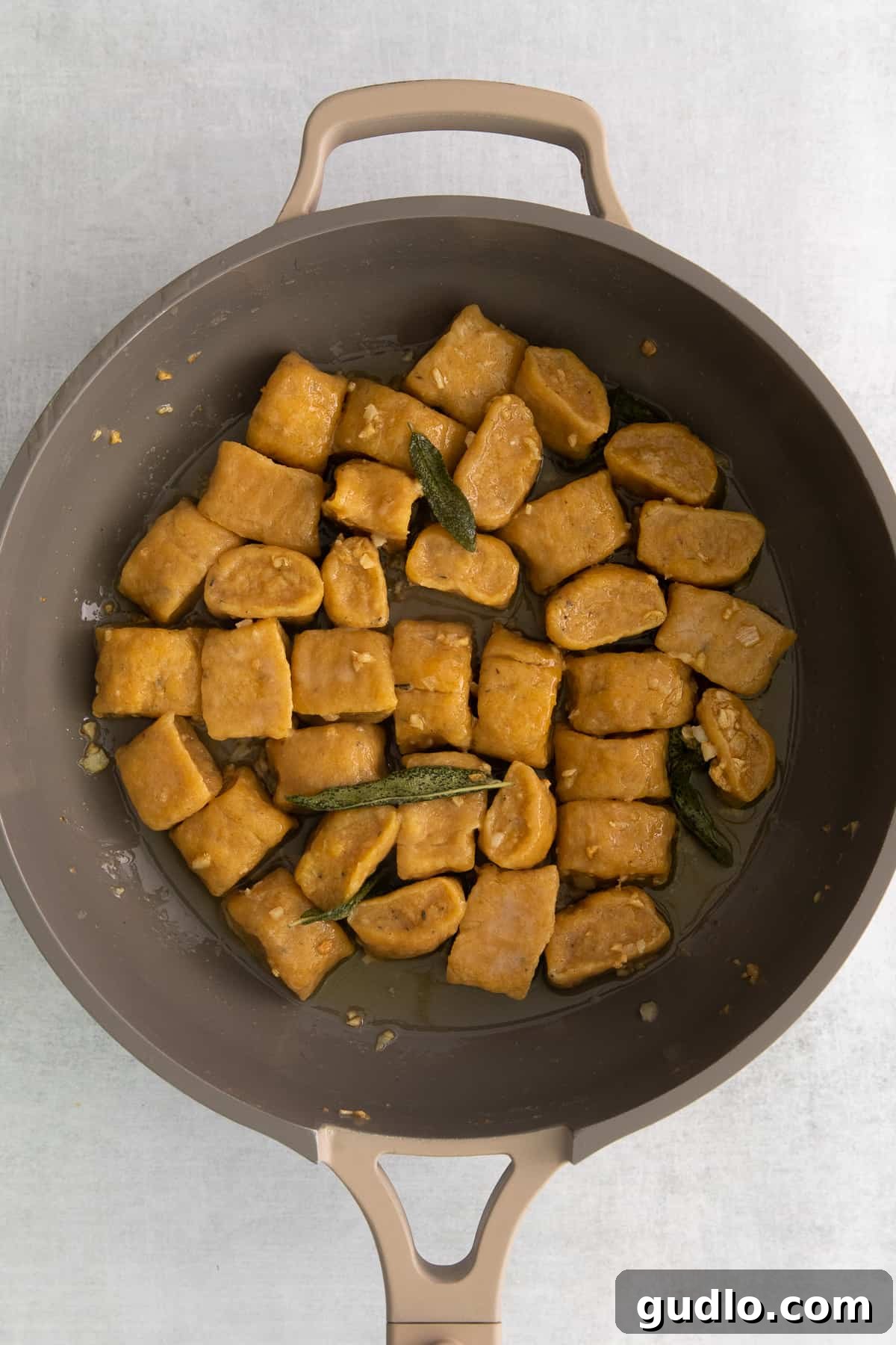 Gnocchi in Sage Butter Sauce Perfectly cooked pumpkin gnocchi simmering in a pan with fragrant sage butter sauce.