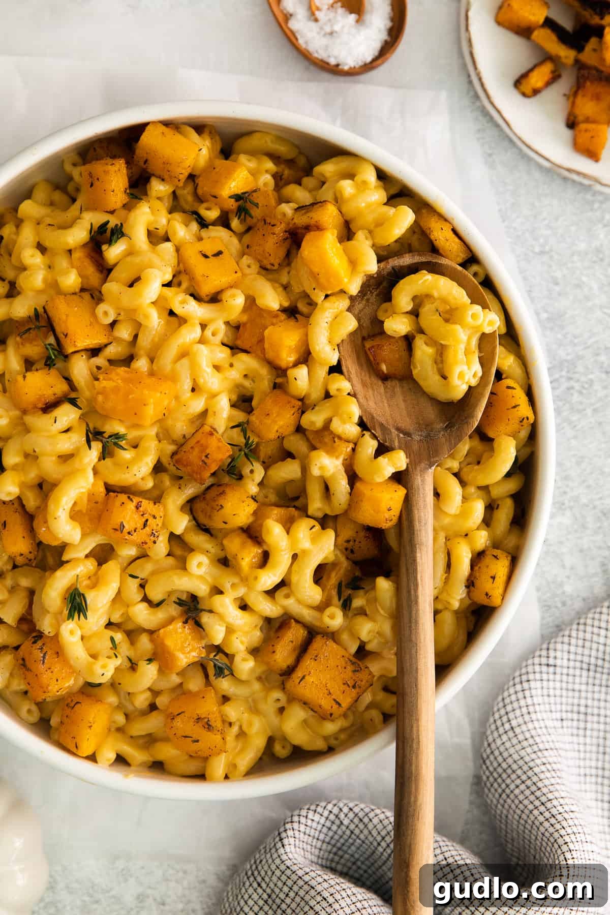 Creamy pumpkin mac and cheese in a rustic bowl with a spoon, ready to be enjoyed.