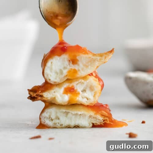 Stack of Crispy Crab Rangoons A beautiful stack of perfectly golden-brown crab rangoons, showcasing their crisp texture, ready for serving with dipping sauce.