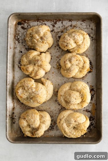 Freshly baked knots with melted butter and Parmesan cheese, showcasing a perfect golden crust.