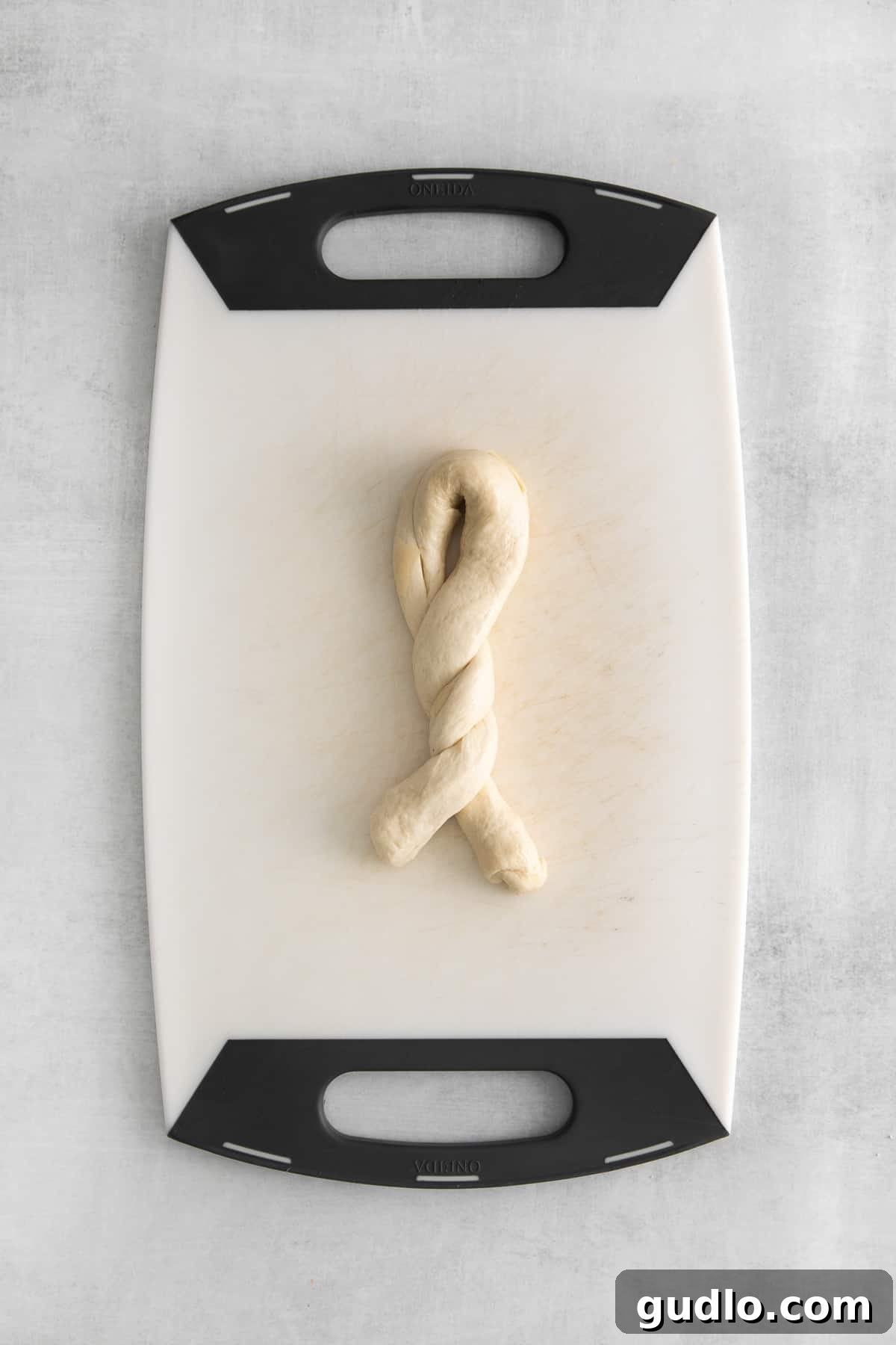 The process of twisting raw dough into the classic knot shape, demonstrating the simple technique.