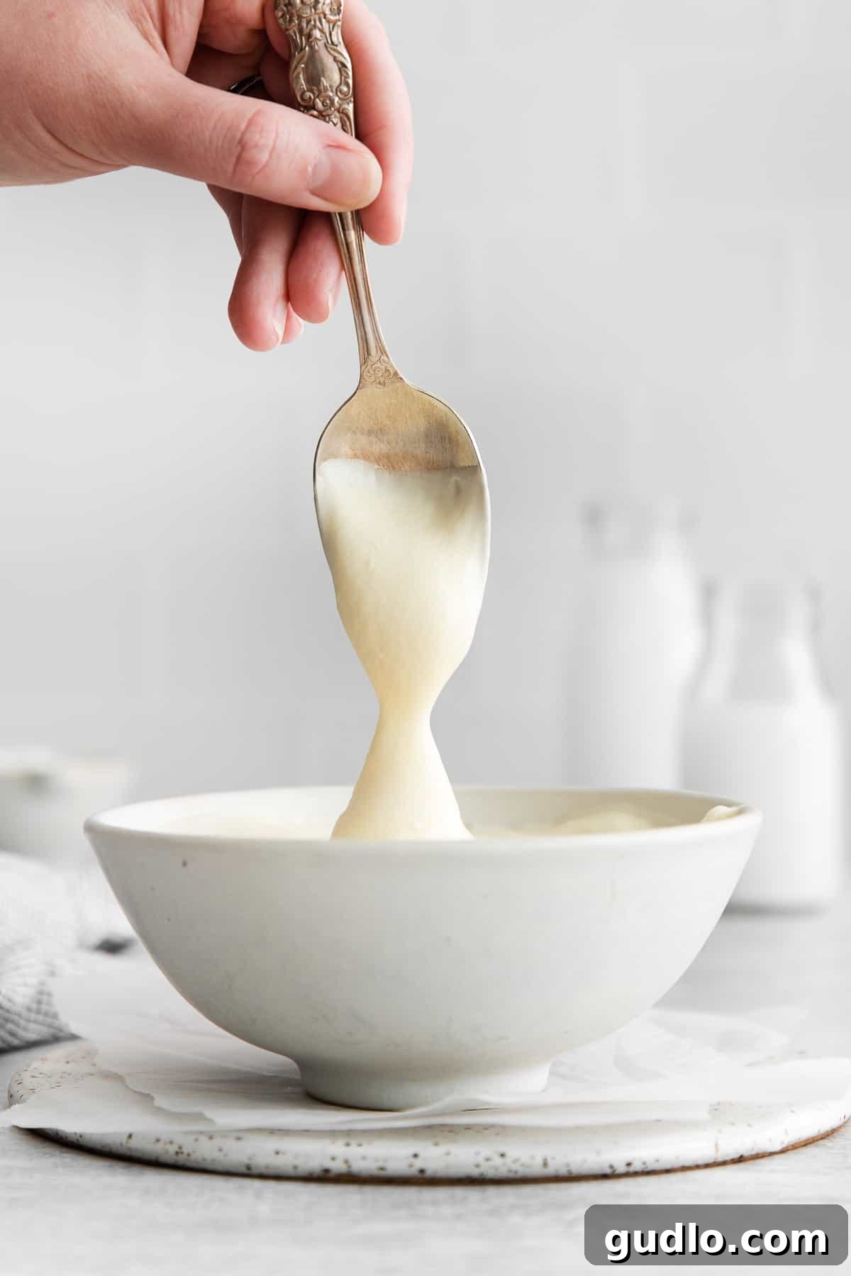 A bowl of freshly made whipped cream cheese frosting, ready to be served or used as a delightful dip for fruits, showcasing its smooth and inviting texture.