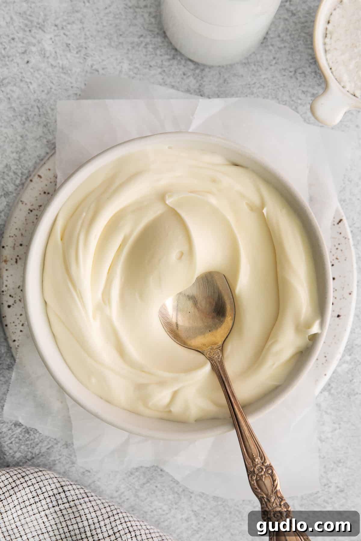 A bowl filled with thick, creamy whipped cream cheese frosting, showcasing its delightful tangy flavor and perfect texture, ready to be enjoyed.