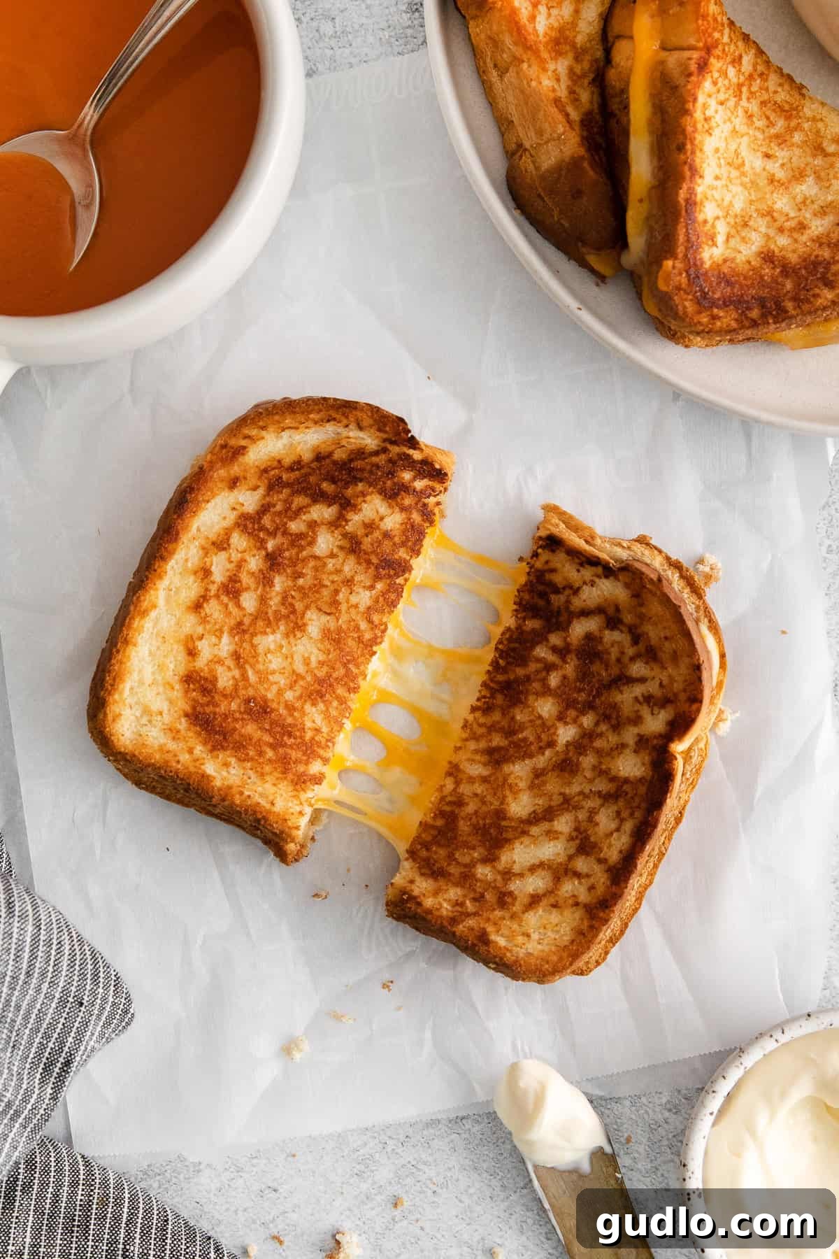 The Secret to Crispy Grilled Cheese: Mayo! Grilled cheese with mayo cut in half, showcasing its incredibly crispy exterior and perfectly melted, gooey interior.
