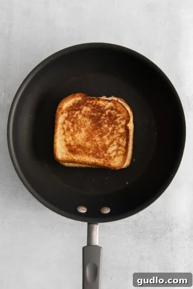 Grilled cheese with mayo cooking in a hot skillet, showcasing the golden-brown crust.