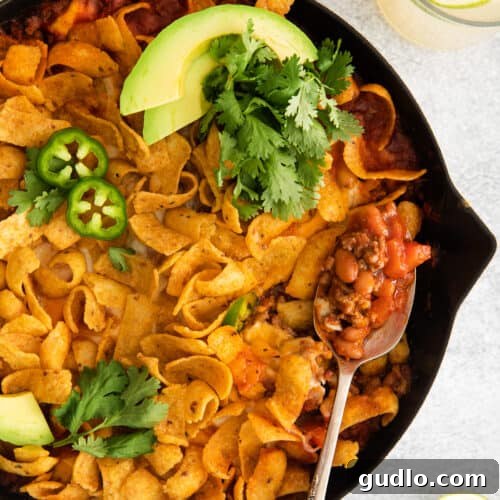 A beautifully presented Cheesy Frito Taco Skillet, golden and bubbly, with a perfect layer of Frito chips and melted cheese.