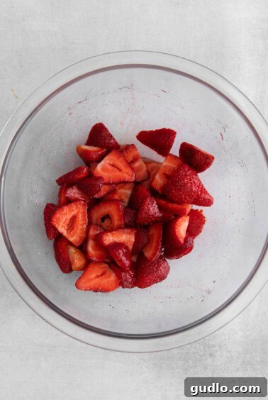 Decadent Strawberry Cheesecake French Toast 10 Sliced strawberries in a glass bowl, macerating with sugar and lemon juice.