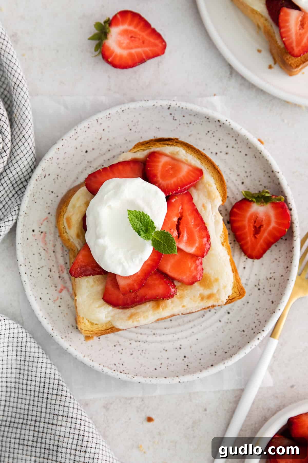 Decadent Strawberry Cheesecake French Toast 8 A perfectly plated slice of strawberry cheesecake french toast, garnished with fresh strawberries and a swirl of whipped cream.