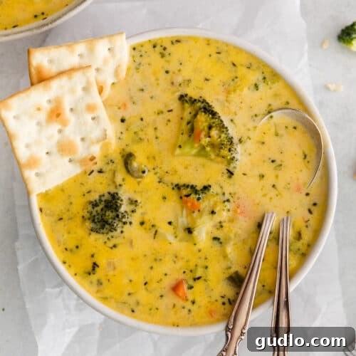 Broccoli potato soup served in a warm bowl with crispy crackers on the side, ready to be enjoyed as a comforting meal.