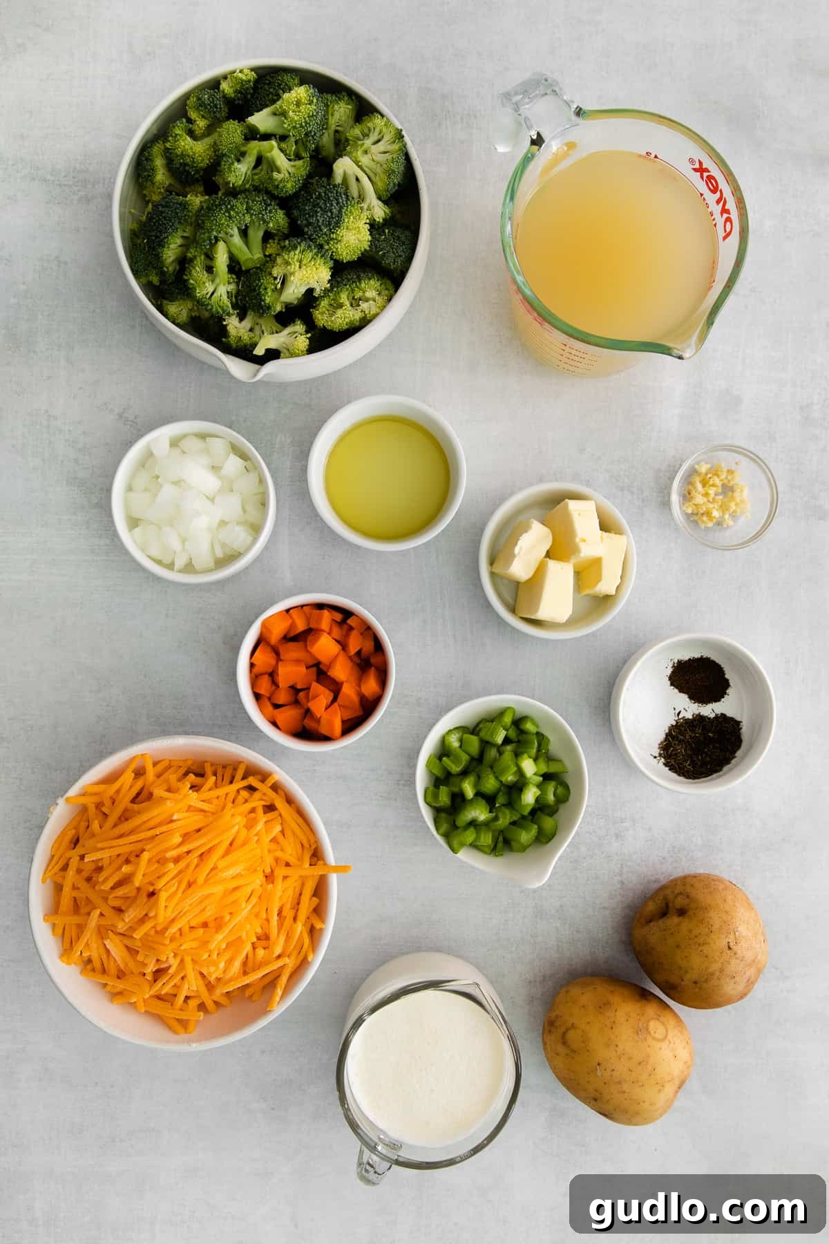 All fresh, vibrant ingredients for broccoli potato cheese soup neatly arranged in small bowls, showcasing quality and readiness for cooking.