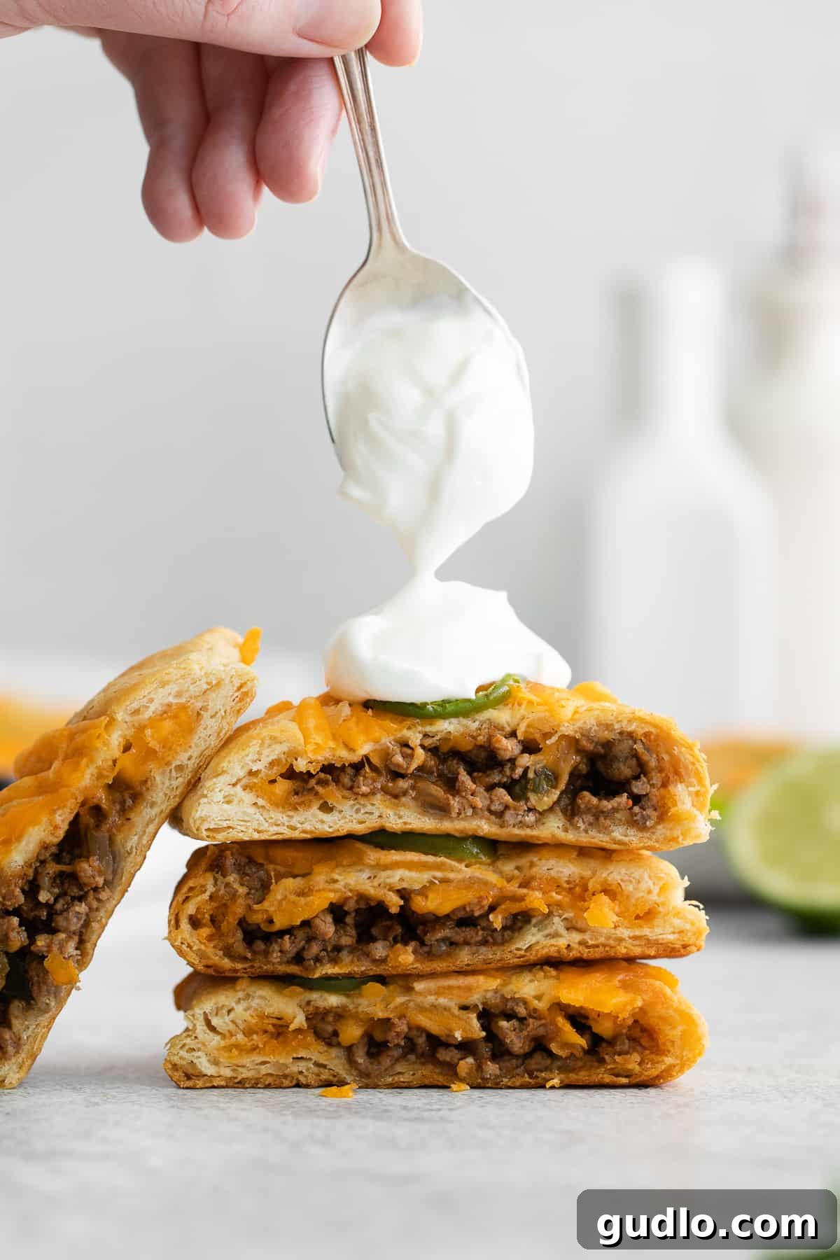 Effortless Taco Pockets 2 Delicious taco pockets topped with a dollop of sour cream and a sprinkle of fresh cilantro, ready to be served.