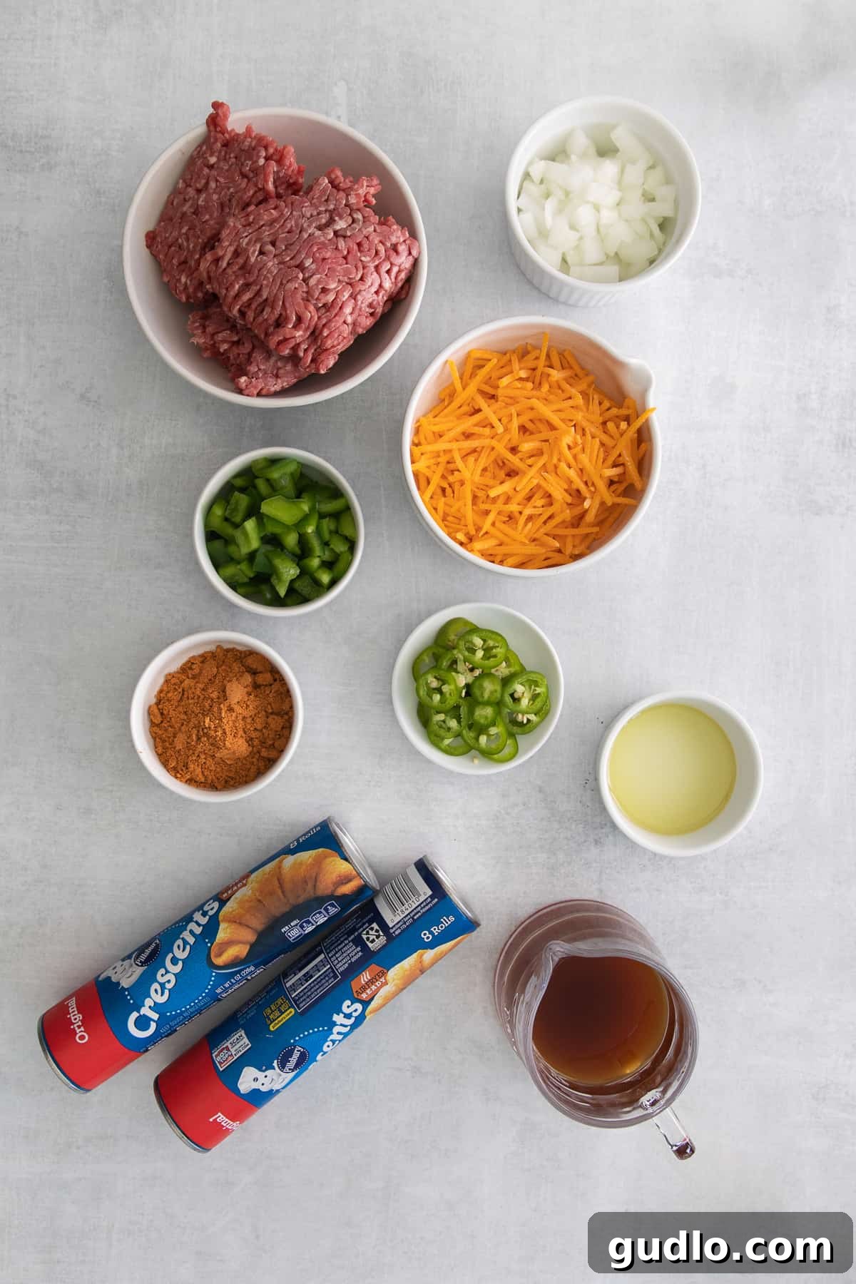 Effortless Taco Pockets 3 A vibrant selection of fresh ingredients for taco pockets including shredded cheddar, diced onions, green bell peppers, ground beef, and taco seasoning.