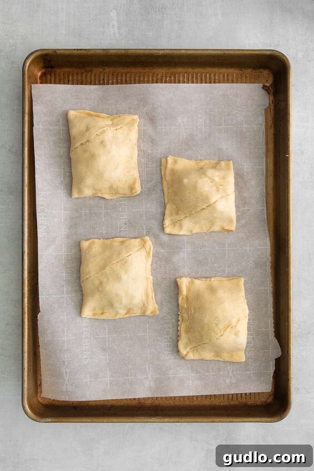 Effortless Taco Pockets 4 Unbaked taco pockets arranged neatly on a baking sheet, ready for the oven.