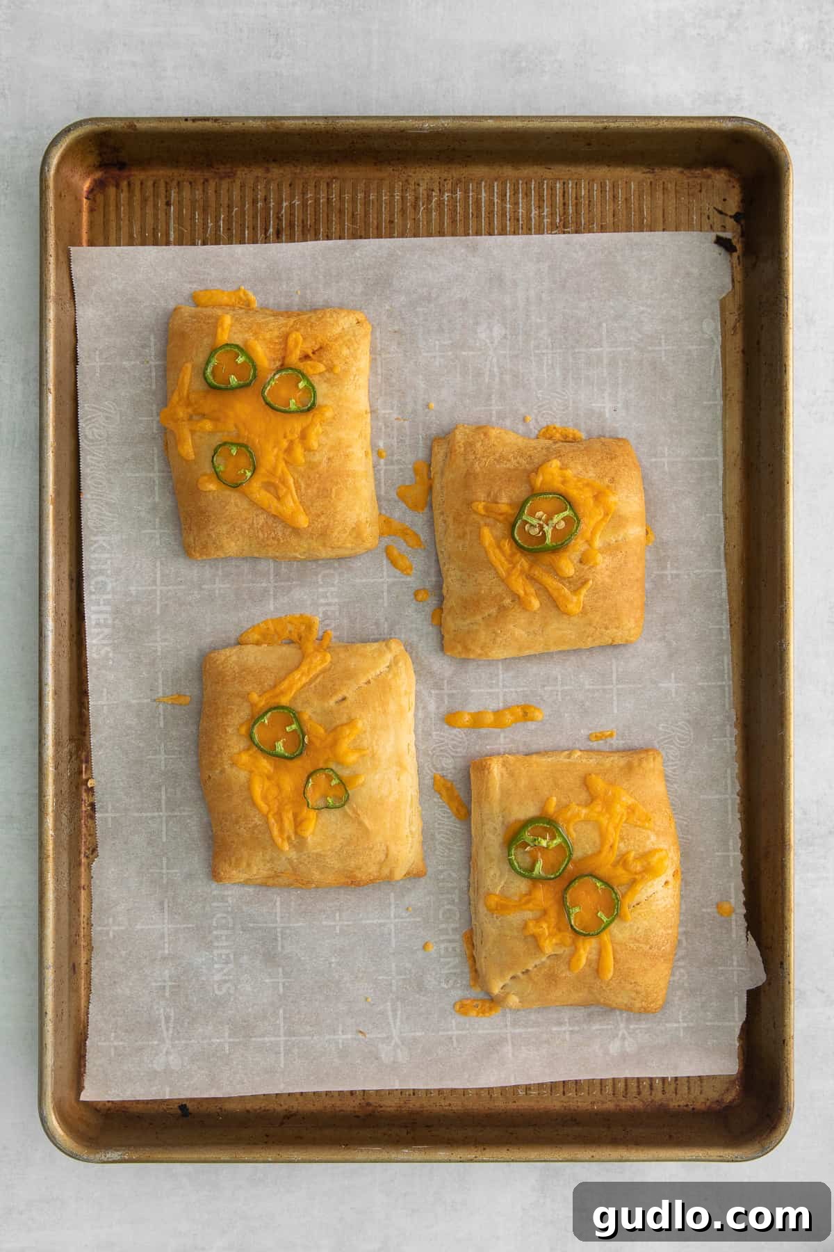 Effortless Taco Pockets 5 Freshly baked taco pockets, golden brown and topped with vibrant sliced jalapeños and melted cheese.