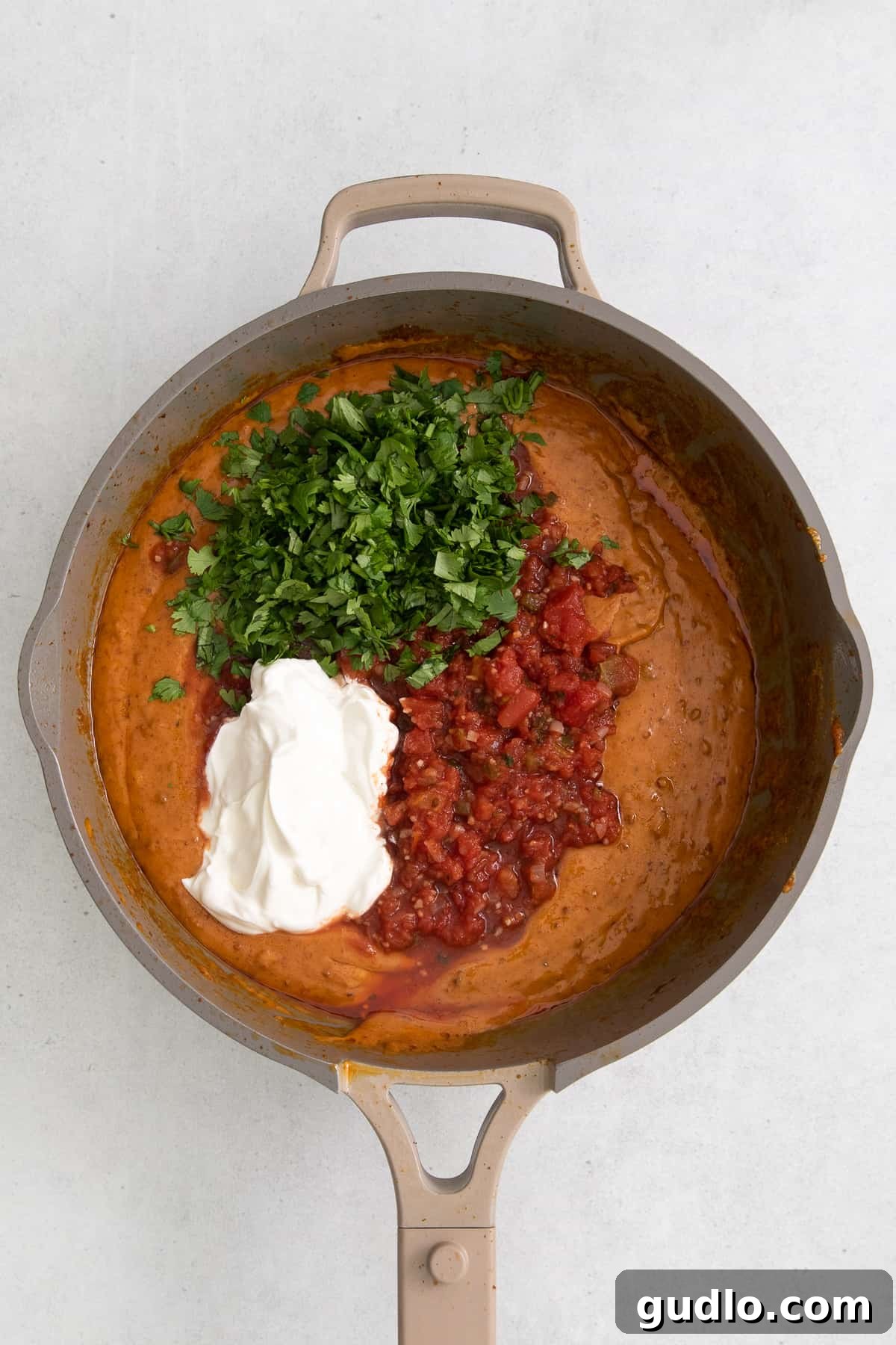 Velveeta Dream Dip 6 Adding cubed Velveeta cheese and pico de gallo into a pan with cooked chorizo, ready to be melted and combined.