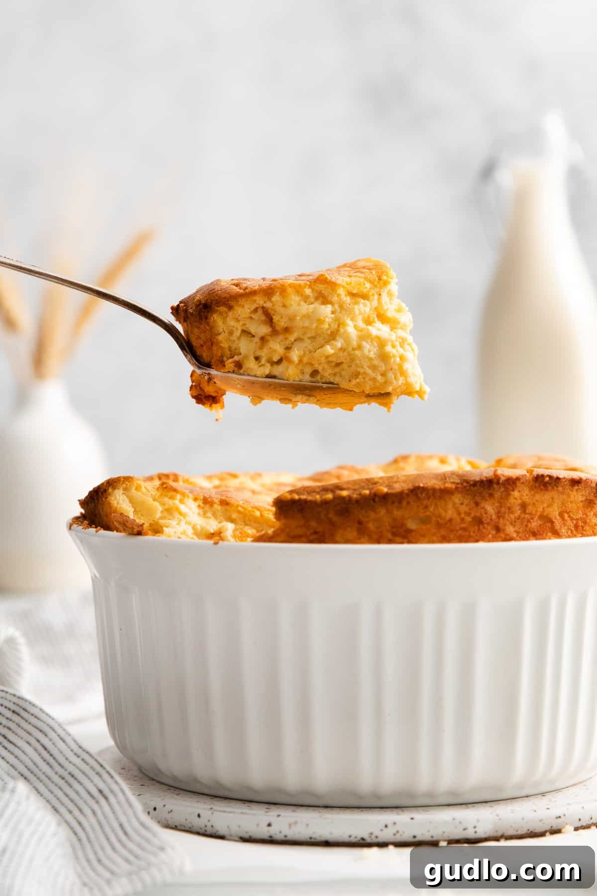A spoonful of fluffy cheese soufflé, showcasing its light and airy texture.