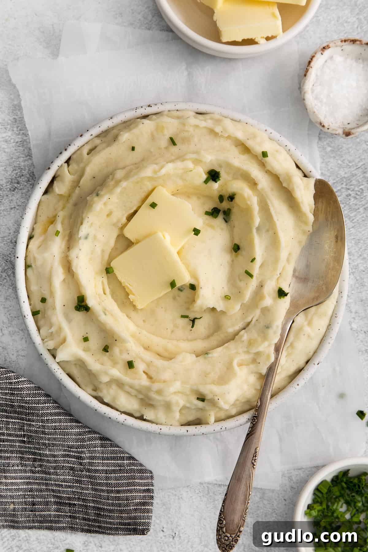 The ultimate creamy and flavorful cream cheese mashed potatoes. Cream cheese mashed potatoes topped with pads of butter and fresh herbs.