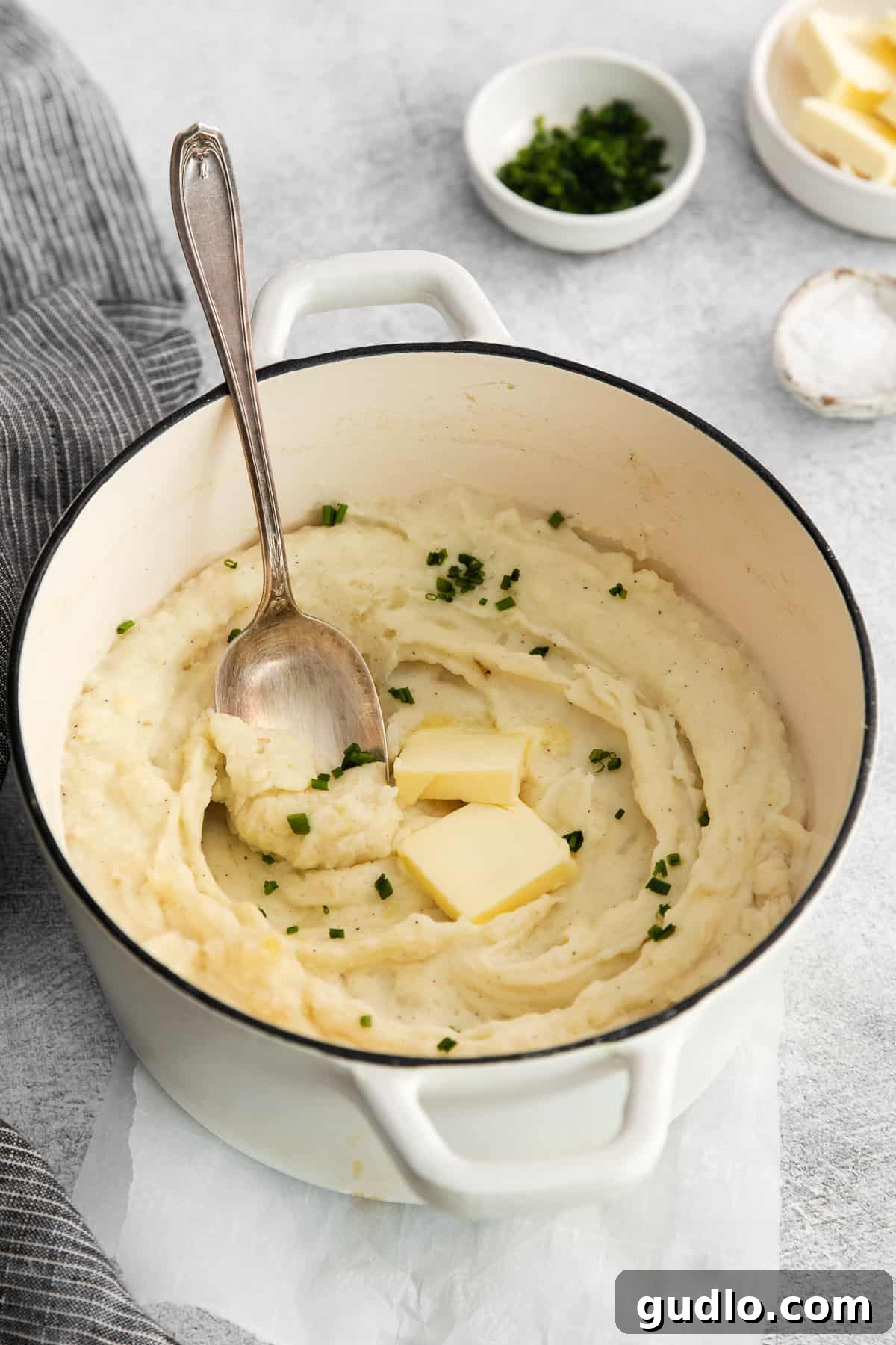 Velvet Smooth Cream Cheese Potatoes 6 A bowl of creamy mashed potatoes with a serving spoon, ready to be enjoyed.