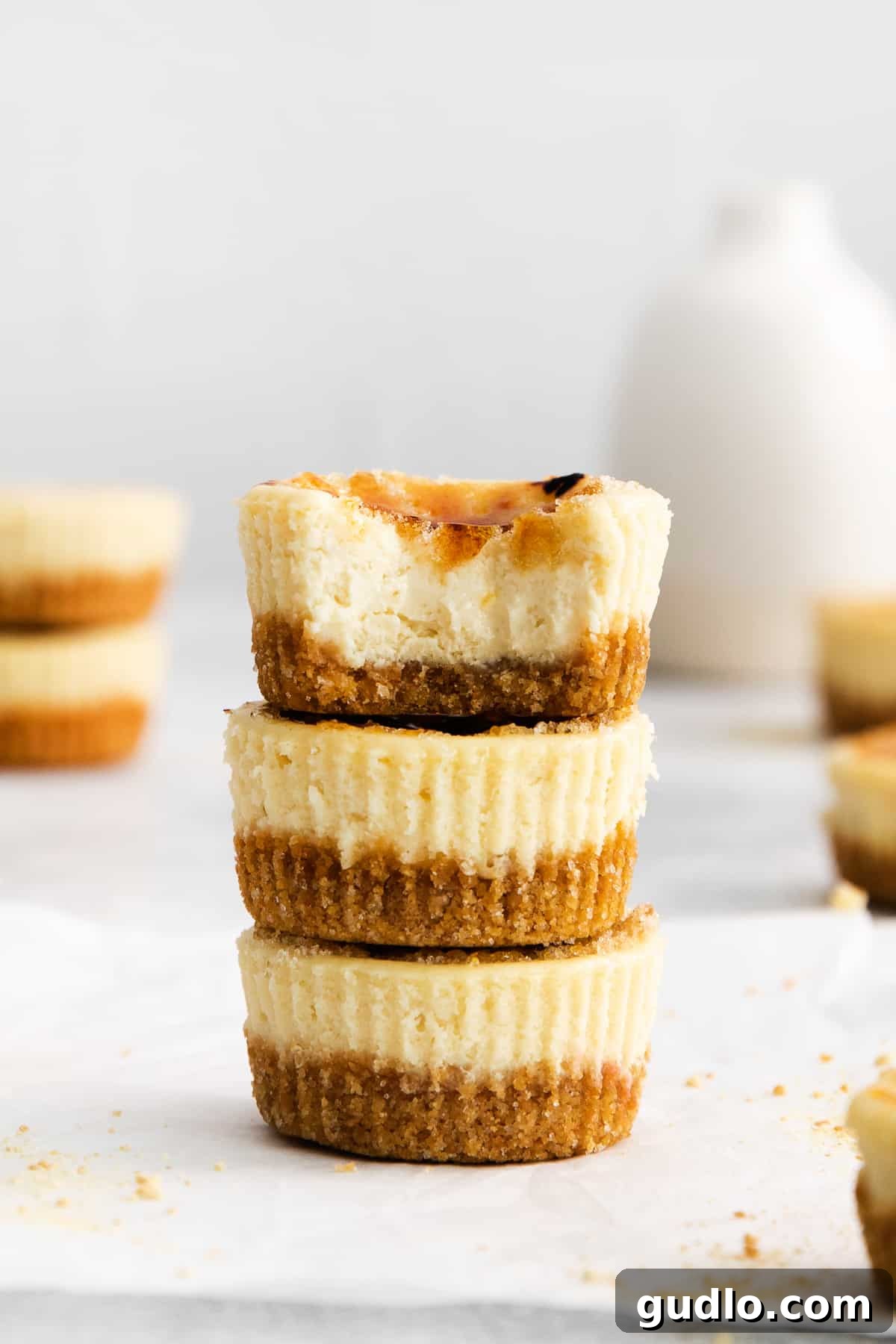 Stacked mini creme brulee cheesecakes with a golden, crisp topping.