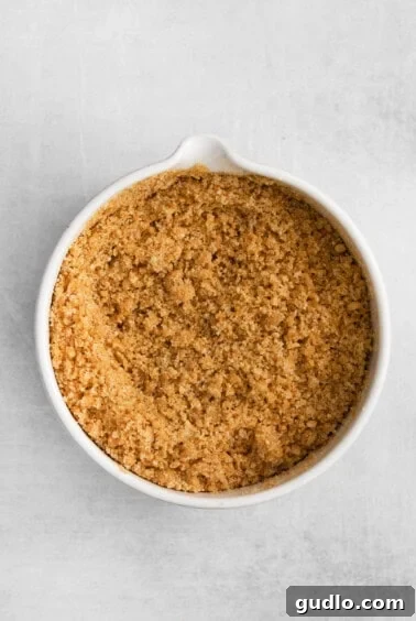 Graham cracker crumbs mixed with butter and sugar in a bowl.