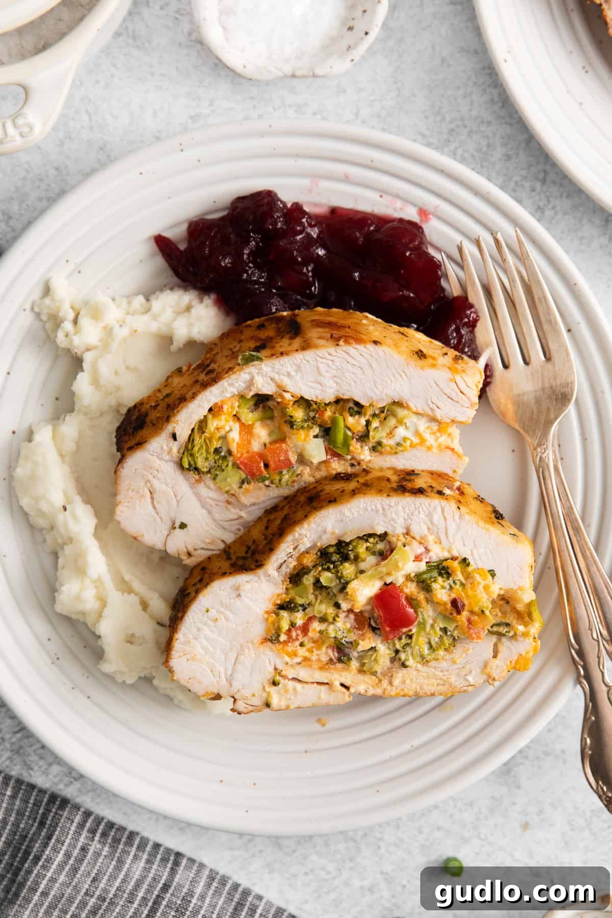Ultimate Cheesy Broccoli Stuffed Turkey Breast Recipe Perfectly sliced stuffed turkey breast on a elegant serving plate, revealing the rich, cheesy broccoli filling.