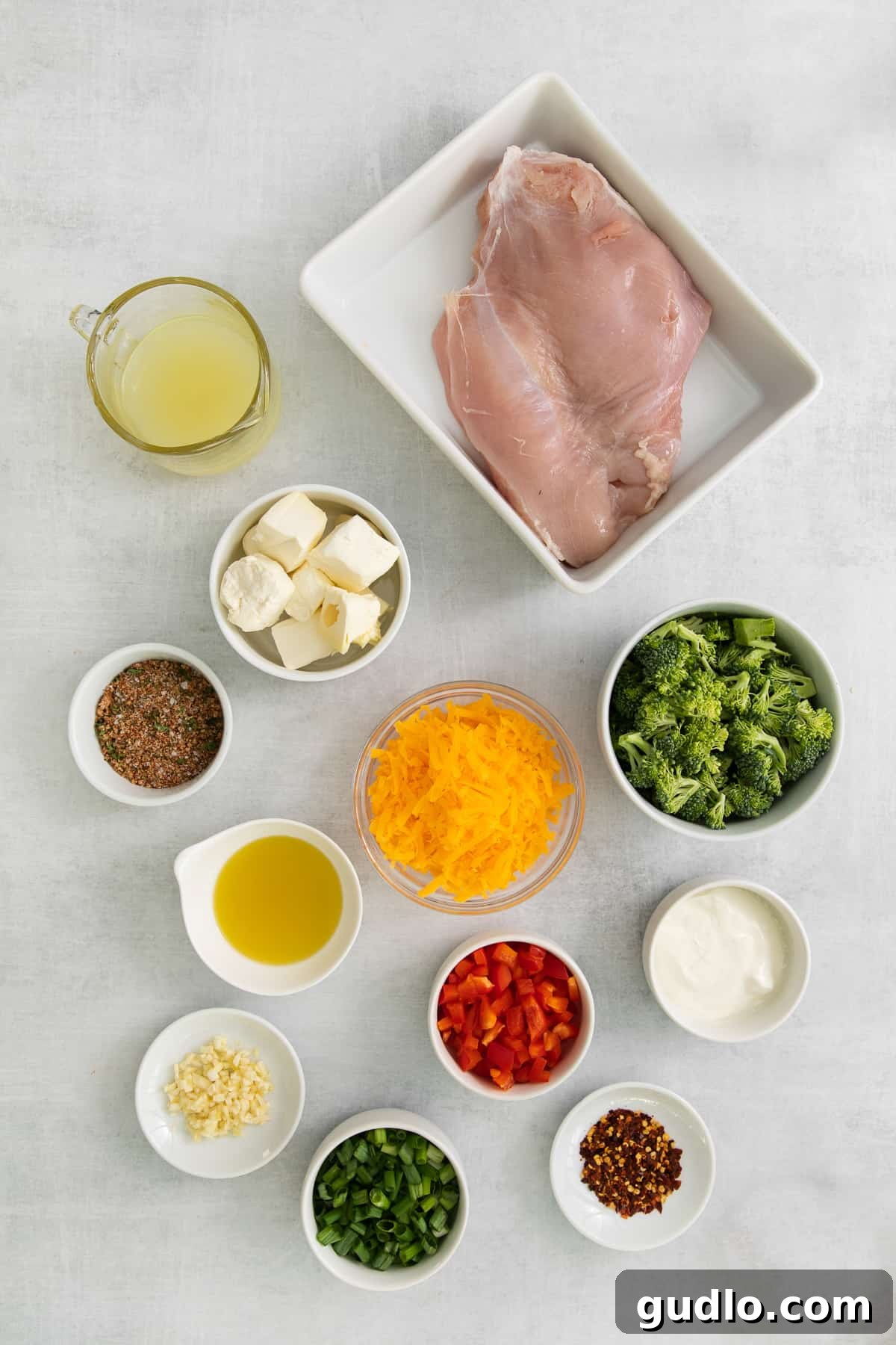 Fresh Ingredients for Stuffed Turkey Breast A vibrant selection of fresh ingredients laid out in bowls, including cream cheese, diced broccoli, bell peppers, green onions, and shredded cheddar, ready for making the stuffed turkey breast filling.