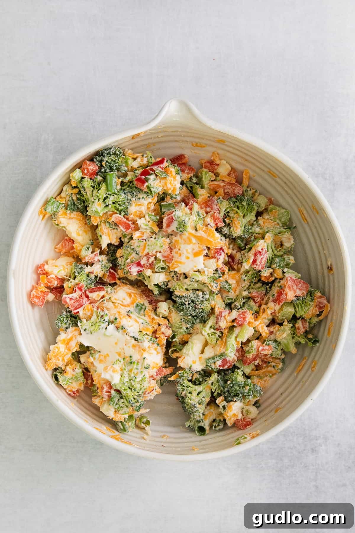 Creamy Stuffing with Cream Cheese Close-up shot of the rich broccoli and cheese stuffing in a bowl, showing the creamy texture and embedded vegetables, with a spoon for mixing.