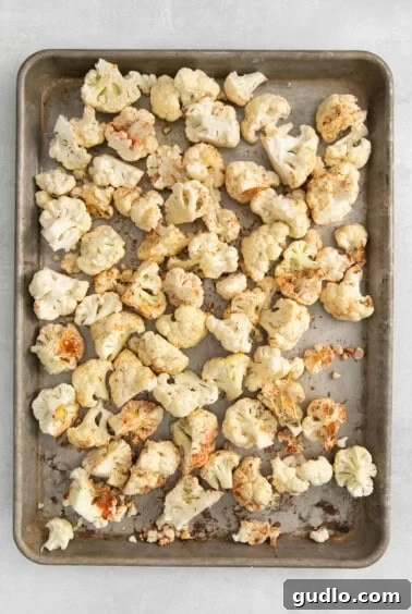Roasted cauliflower on a baking sheet, golden and tender.