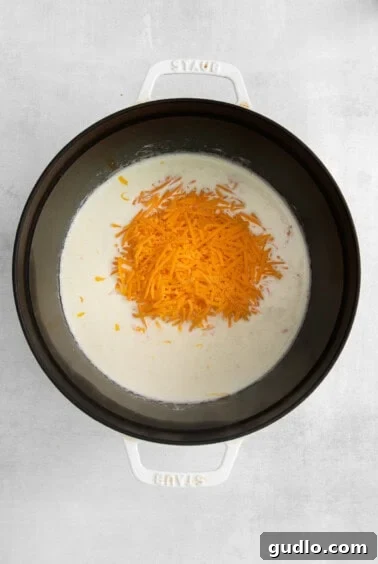 Creamy cheese sauce bubbling gently in a saucepan.