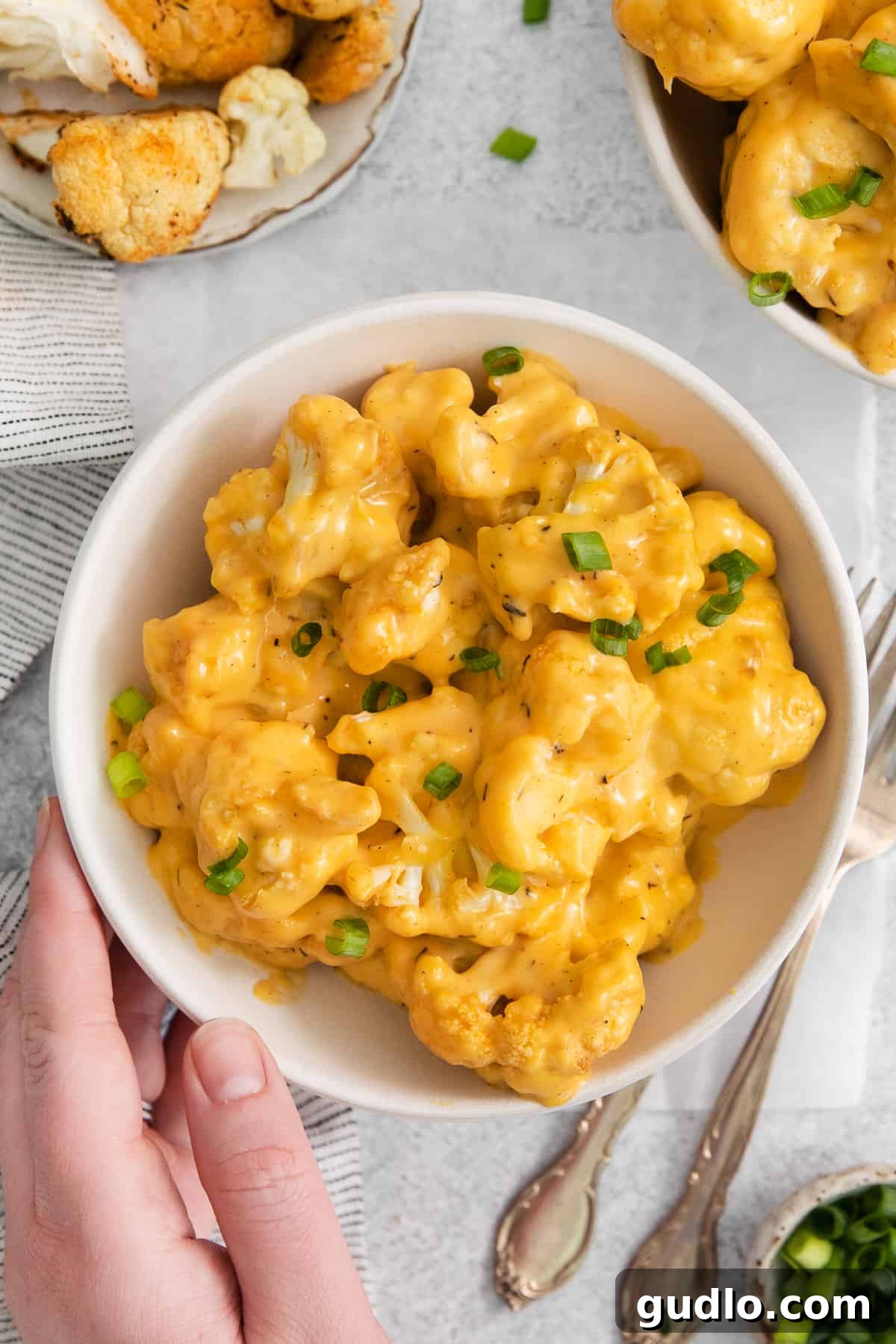 Another appealing shot of cauliflower mac and cheese in a bowl, highlighting its rich, golden hue.