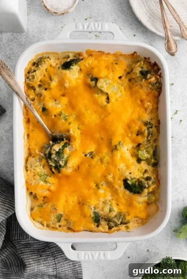 A casserole dish with cooked broccoli and cheese, resting.