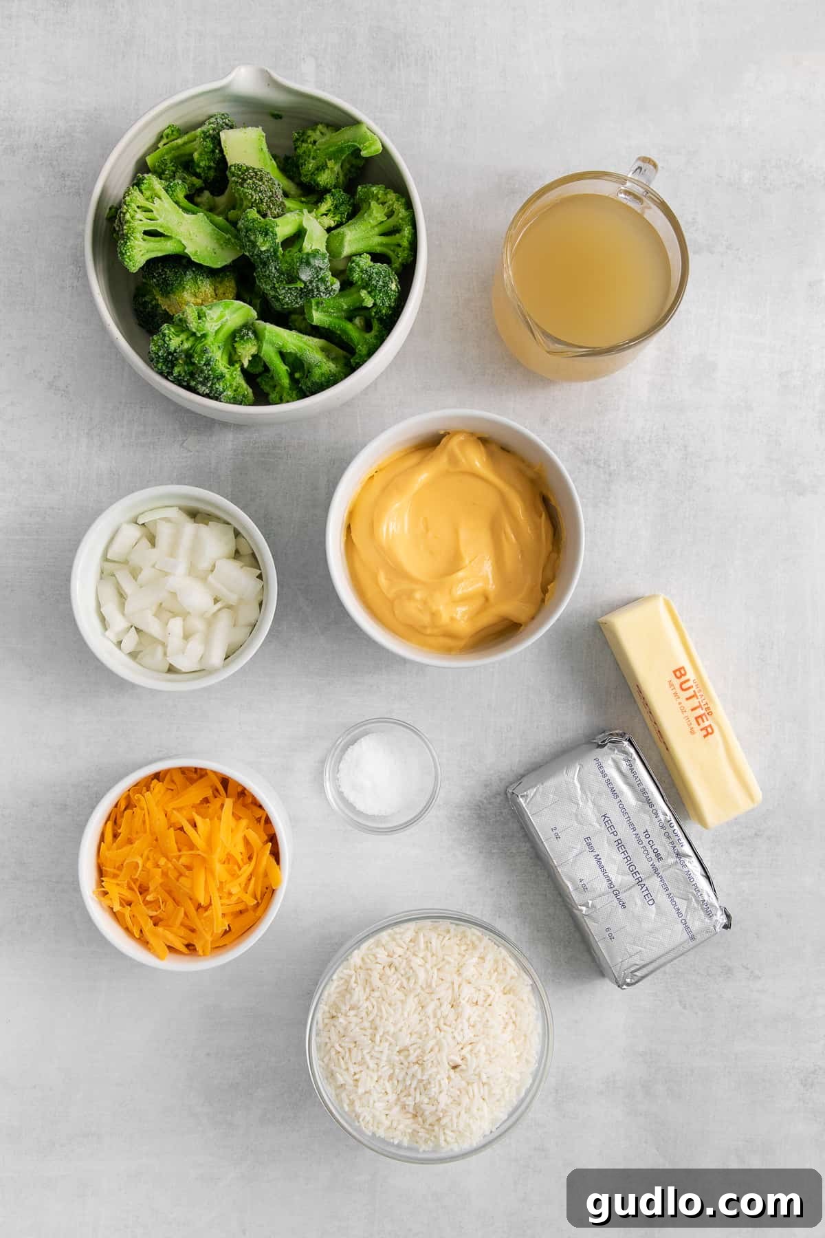 Ingredients for broccoli cheese casserole laid out in individual bowls.