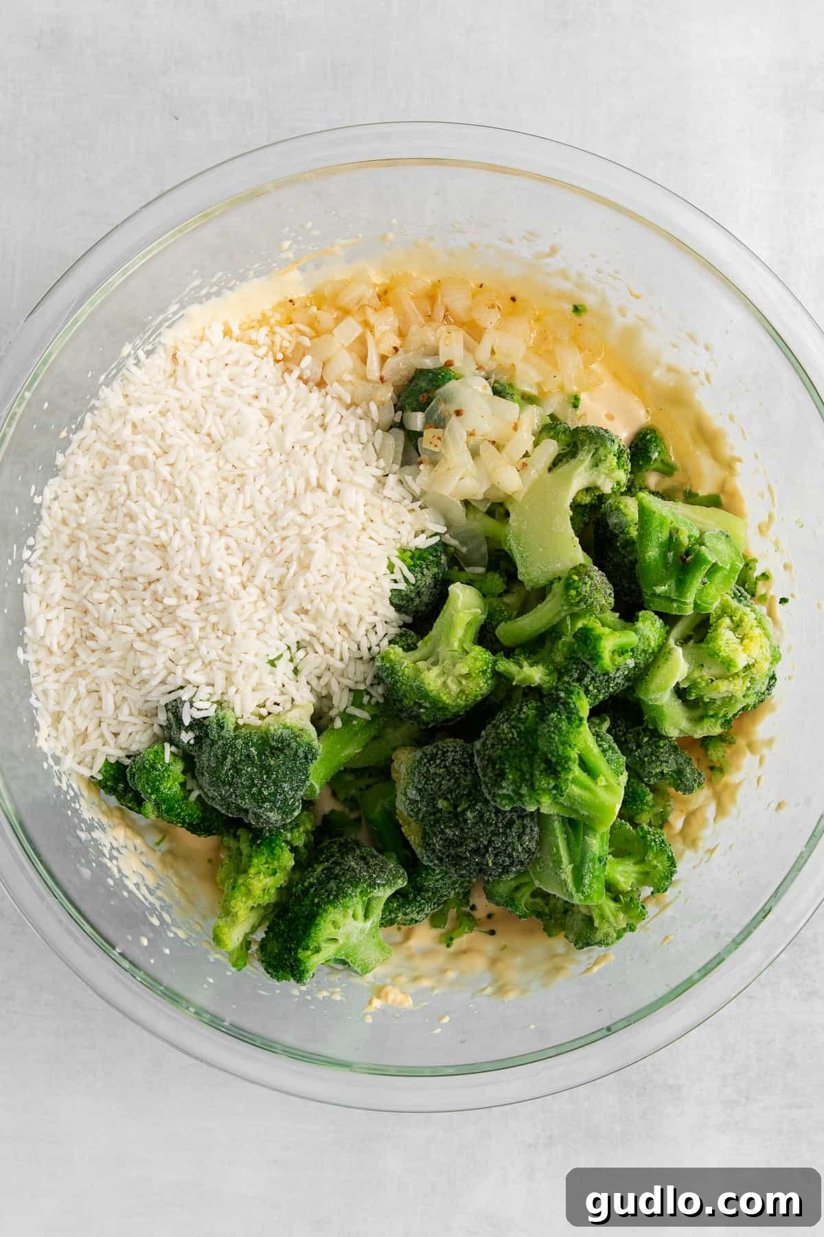 Broccoli, cheese sauce, and rice mixed in a large bowl before baking.