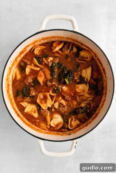 Soul-Satisfying Tortellini Soup 7 a pot of soup with meat and vegetables in it.