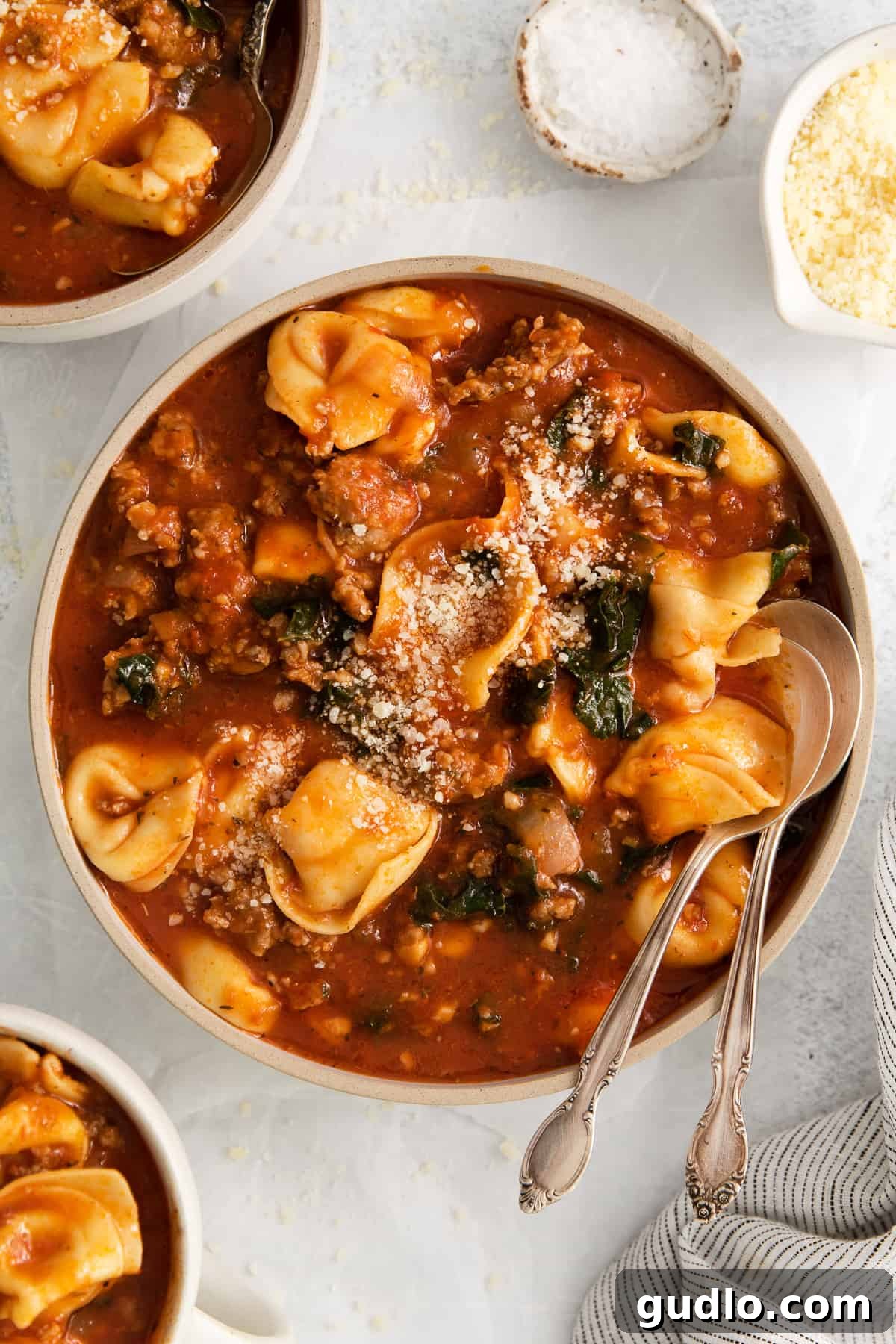 Enjoying a Bowl of Hot Cheese Tortellini Soup A bowl of cheese tortellini soup with a spoon, ready to eat.