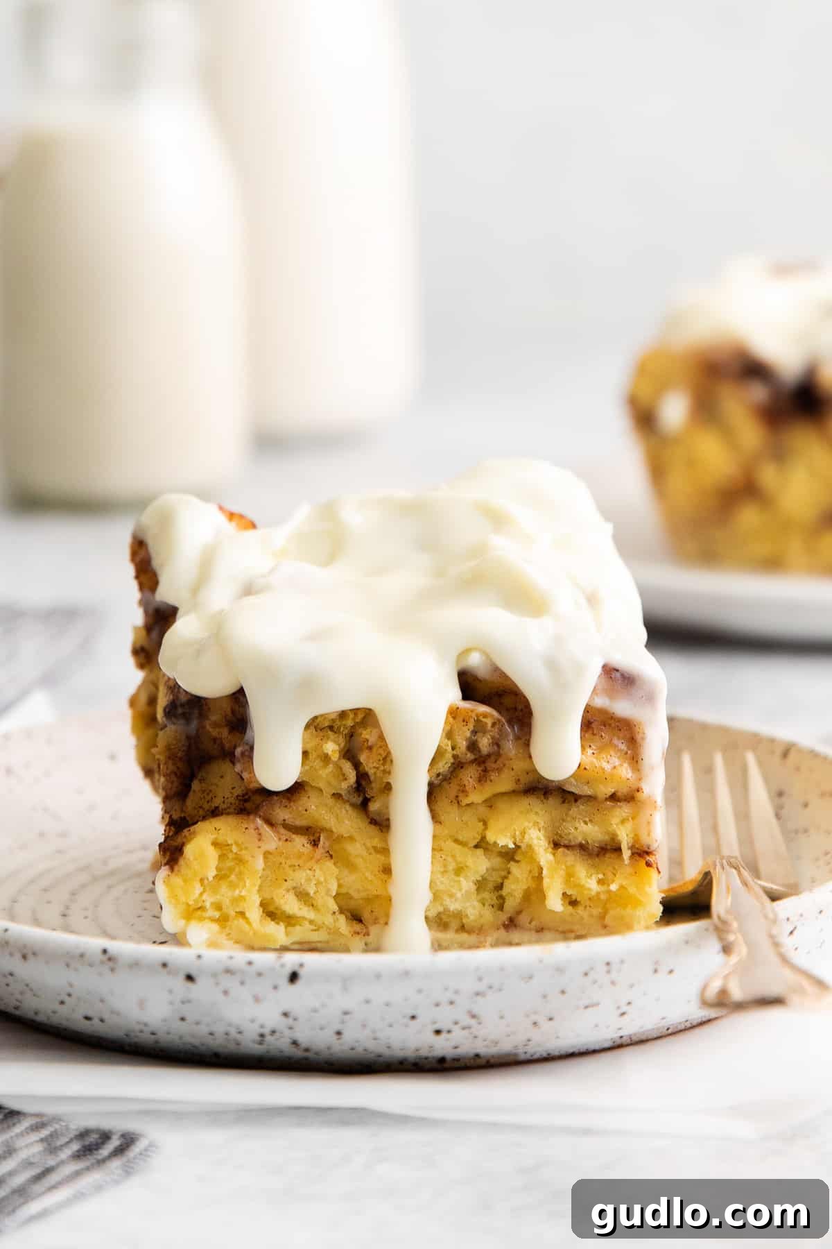 Single serving of delicious cinnamon roll casserole. A perfectly portioned slice of cinnamon roll casserole on a plate, showing its layers and gooey texture.