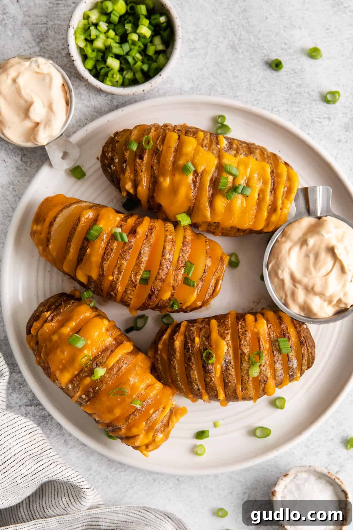 Multiple hasselback potatoes on a plate, showcasing their unique appearance.